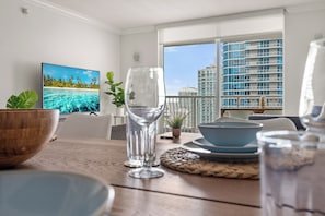 A dining area with a view of a cityscape through large windows.