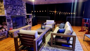 Un espace intérieur accueillant avec une cheminée en pierre, des meubles en bois et des guirlandes lumineuses.