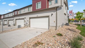 A modern multi-story building with a garage entrance, a red accent wall, and a sign for ICON Cinema VIP Theater. - Close to USAFA & St Francis Hospital (Colorado Springs)