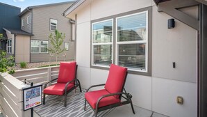 A building with two red chairs on a covered porch, a small tree, and a sign with text. - Close to USAFA & St Francis Hospital (Colorado Springs)