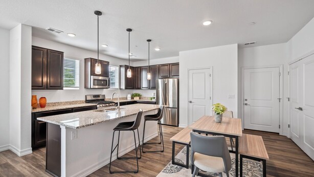 A modern kitchen with a central island, stainless steel appliances, and pendant lighting. - Close to USAFA & St Francis Hospital (Colorado Springs)