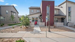 A modern residential building with a paved driveway, a small garden area, and a red chair. - Close to USAFA & St Francis Hospital (Colorado Springs)