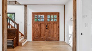 A wooden door with glass panels, a staircase with wooden steps, and a white wall. - The Barn at Winterfound Farm with Hot Tub & Views (Woodstock)