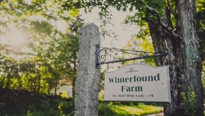 Schild für Winterfound Farm mit einem Baum im Hintergrund.