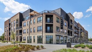 A multi-story residential building with a modern architectural design, featuring balconies and large windows.