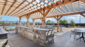 An outdoor barbecue area with a stone grill and seating.