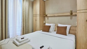 Ein Hotelzimmer mit einem großen Bett, einem Holzkopfteil und einem Fenster mit Vorhängen.