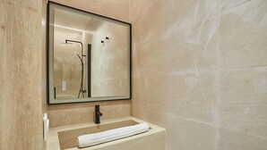 Ein Badezimmer mit großem Spiegel, Waschbecken und Handtuch.