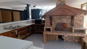 A kitchen with a brick oven, a microwave, and a sink.