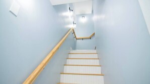 Un escalier avec des rampes en bois et des marches blanches.