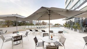 A rooftop terrace with outdoor seating, umbrellas, and a pool. - Apartment Hotel estelar (Barranquilla)
