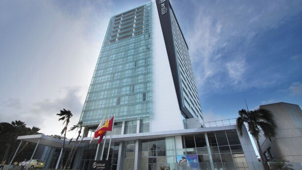 A tall, modern glass building with the name "Estelar Alto Prado" on its facade. - Apartment Hotel estelar (Barranquilla)