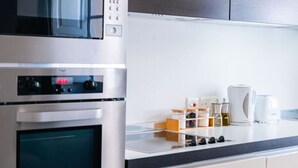 Una cocina moderna con electrodomésticos de acero inoxidable, un reloj digital y una cafetera.