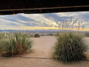 A view through a window with a dirt path leading to a desert landscape, with mountains in the background. - Hilltop Tavern and Inn (Apple Valley)