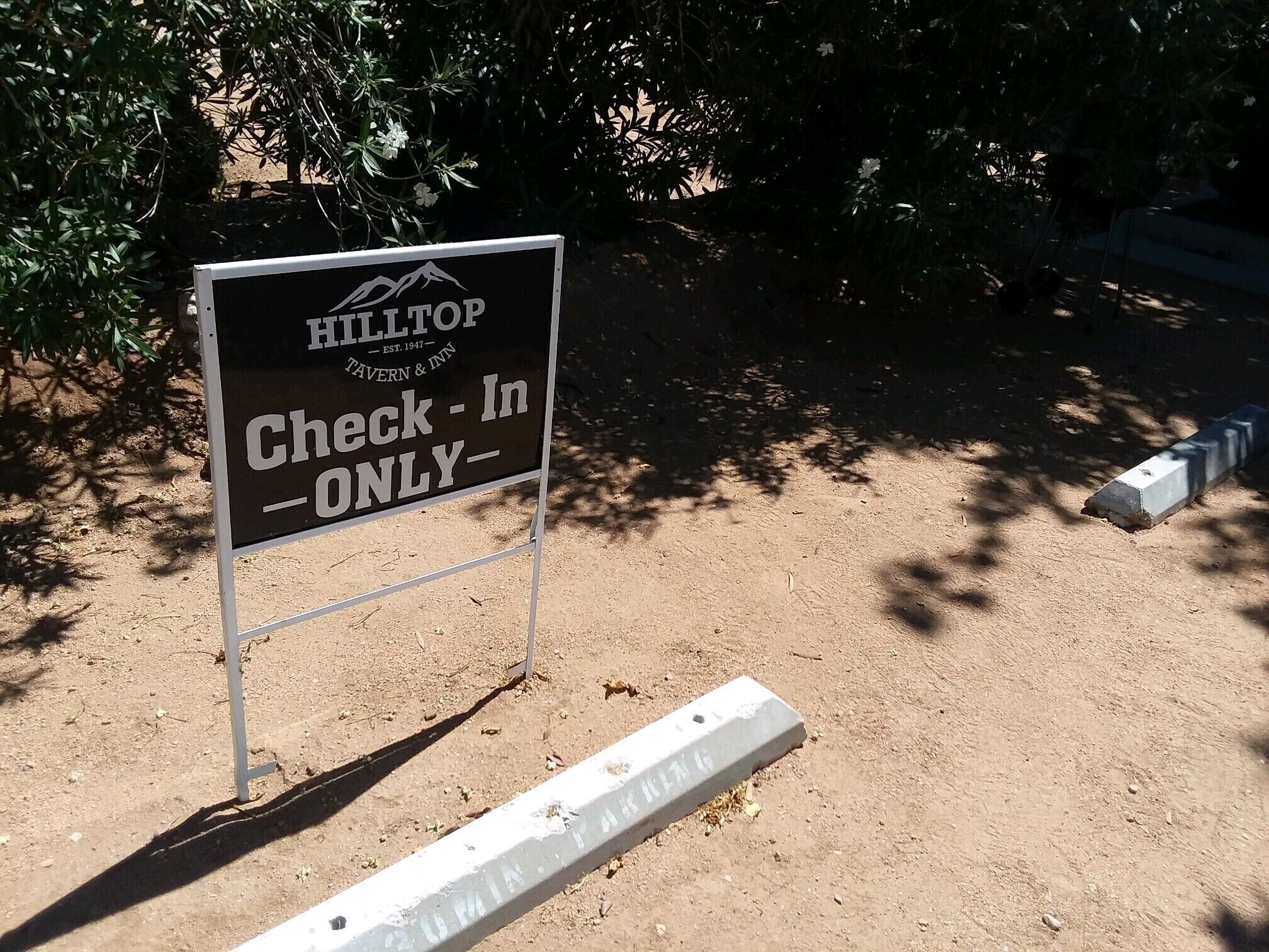 Señal para Hilltop Tavern & Inn con la instrucción 'Check-In Only'.