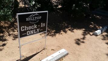 Señal para Hilltop Tavern & Inn con la instrucción 'Check-In Only'.