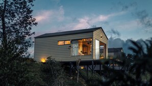 A modern house with a deck, surrounded by greenery. - Hotel Mito Guatapé (Guatapé)