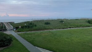 A grassy area with a pathway leading to a beach. - Beach Lovers, Oceanview, Cute 1 BR, 2 full BA condo in Surf City sleeps 5 (Surf City)