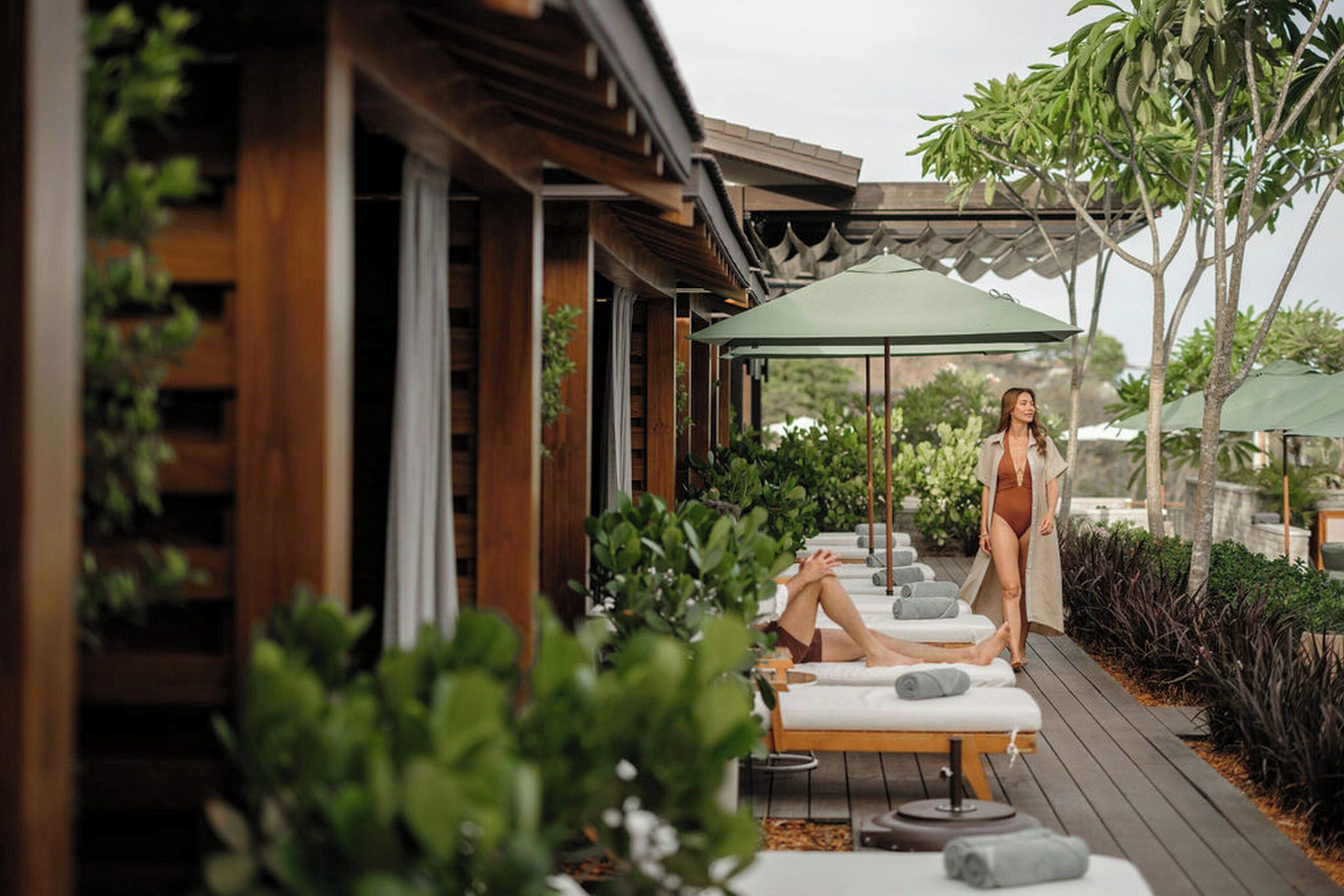 Una terraza de madera con mobiliario exterior y un espacio cubierto.