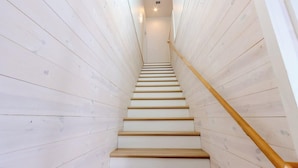 A wooden staircase with a handrail, leading upwards. - Private Pool & Rooftop Deck w/ Water Views (Port Aransas)
