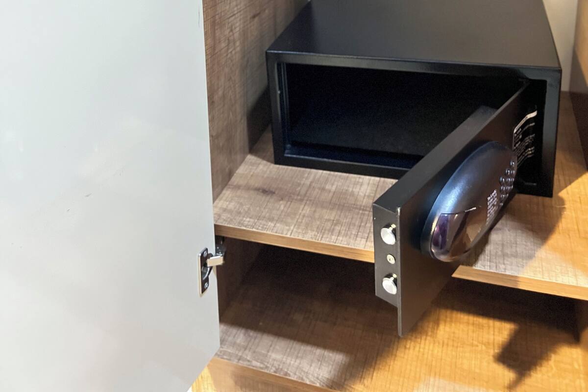 A closed door with a small wooden shelf and a black electronic device on it.