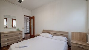 Ein Schlafzimmer mit einem Bett, einem Schminktisch, einem Spiegel und einem Kleiderschrank.