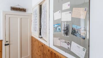 A bulletin board with various postcards and letters pinned to it.