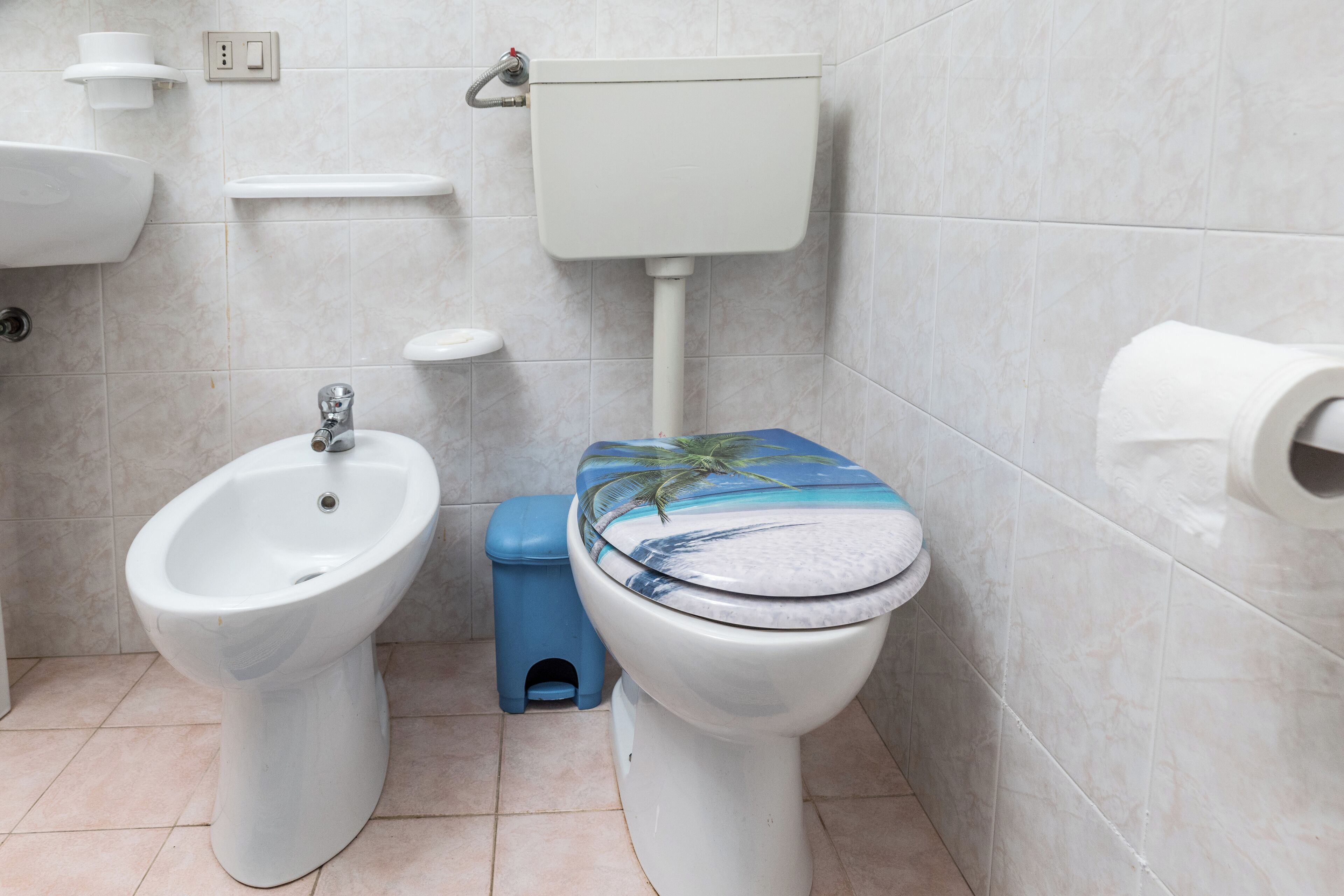 Ein Badezimmer mit Bidet, Toilette, Waschbecken und einem Mülleimer.