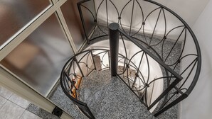 A spiral staircase with a metal railing and a granite floor. - Casa Del Sarto (Sperlinga)