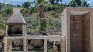 A stone-built outdoor kitchen with a chimney, a sink, and a wooden shower enclosure. - Villa Ginevra (Santa Ninfa)