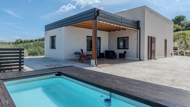 A modern house with a pool, outdoor seating, and a covered patio area. - Villa Ginevra (Santa Ninfa)