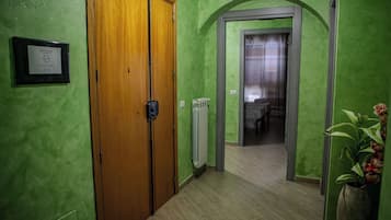 Een gang met groene wanden, een houten deur en een radiator.