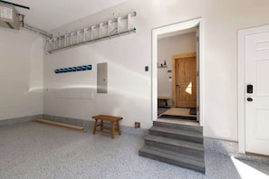 A hallway with a wooden bench, a door, and a staircase leading to another room.