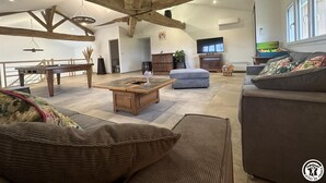 A spacious living room with exposed wooden beams, a pool table, a sofa, and a television. - Champ Clair - SAINT BENIGNE (SAINT BENIGNE)