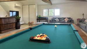 A pool table with balls, a sofa, and a wooden ceiling. - Champ Clair - SAINT BENIGNE (SAINT BENIGNE)