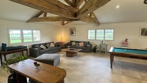 A spacious living room with exposed wooden beams, a pool table, and comfortable seating. - Champ Clair - SAINT BENIGNE (SAINT BENIGNE)