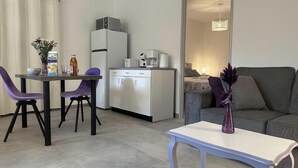 Ein gemütlicher Wohnraum mit Essbereich, Küchenzeile und einer Couch.