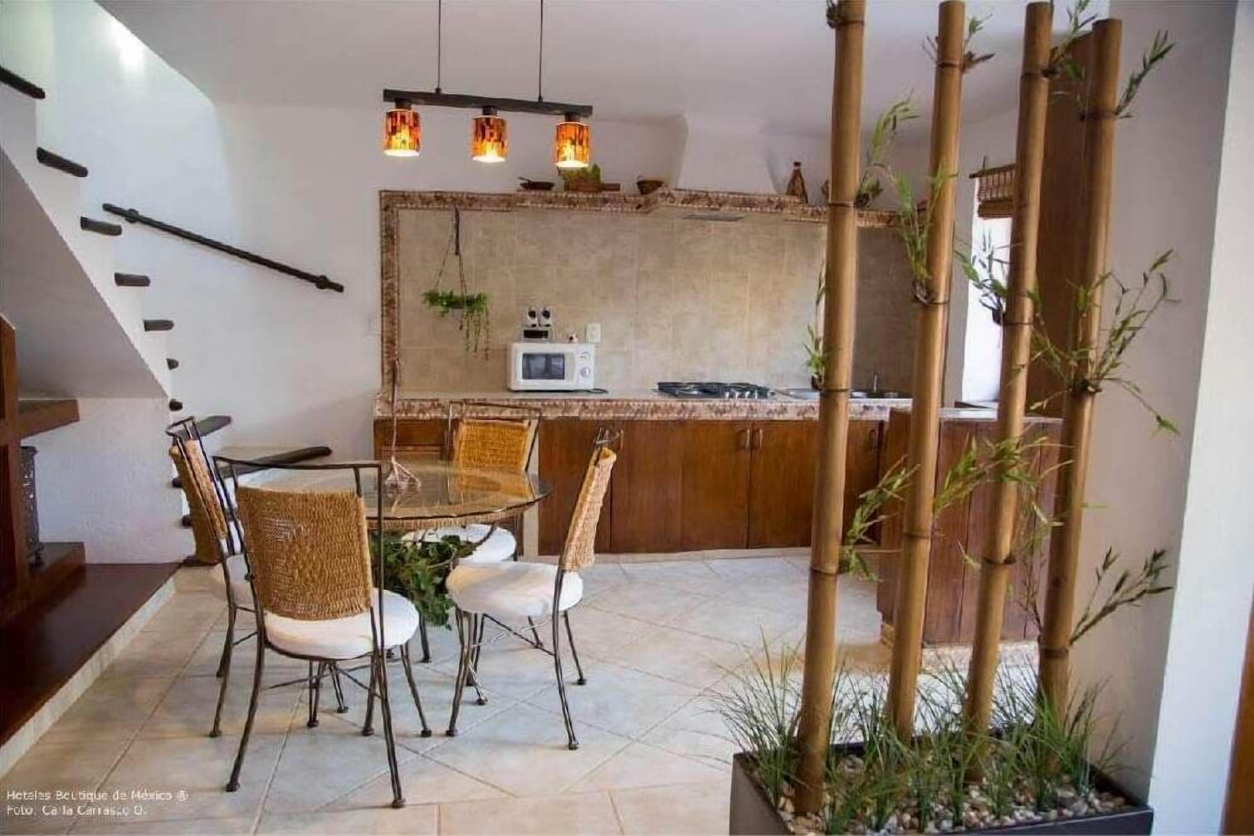 A modern kitchen with a microwave, a dining table with chairs, and a staircase.