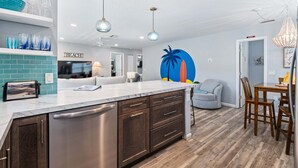A modern kitchen with a large island, built-in appliances, and a dining area with a wooden table and chairs.