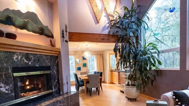 A modern living room with a fireplace, wooden furniture, and a large window. - The Mountain House- ultra quiet, secluded (Corvallis)
