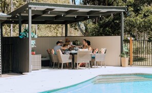 An outdoor patio with a covered seating area, a pool, and a fenced garden. - Palmers Lane Estate 3BR Cabin. Modern facilities. For up to 7 plus shared pool (Pokolbin)