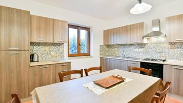 A modern kitchen with wooden cabinets, a tiled backsplash, and a dining table with chairs.
