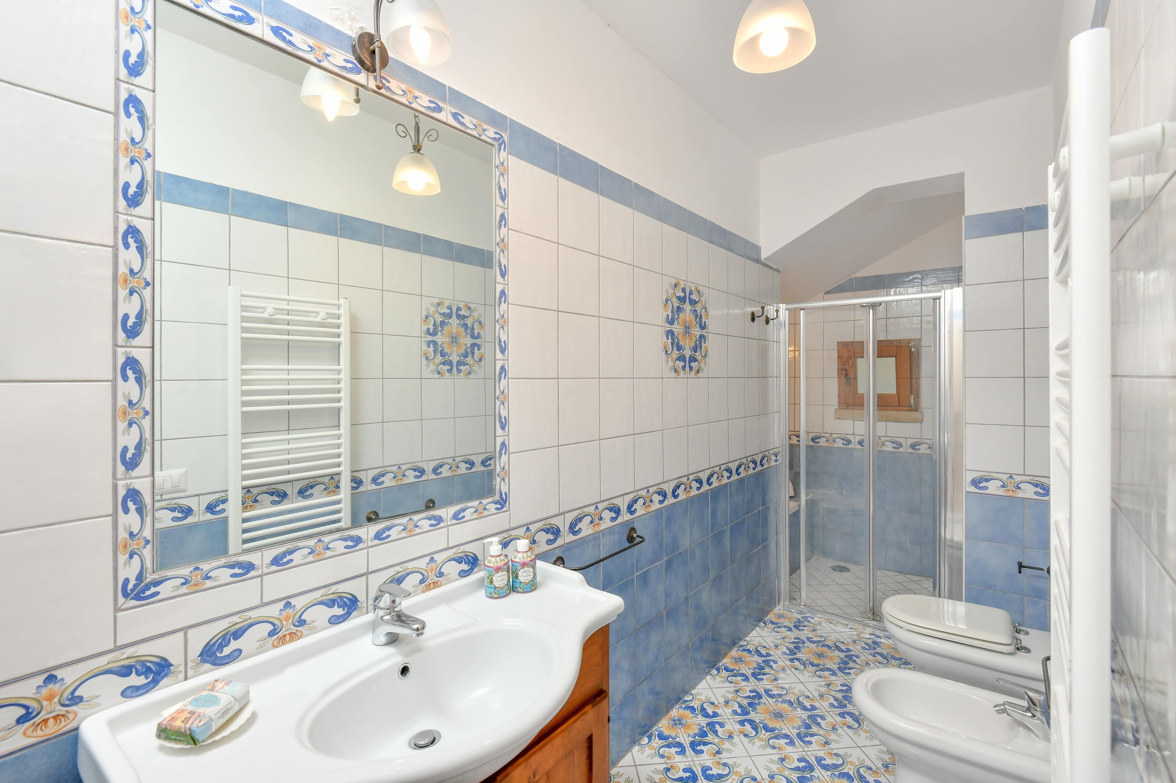 Un baño con un lavabo blanco, un espejo, una ducha y un inodoro.