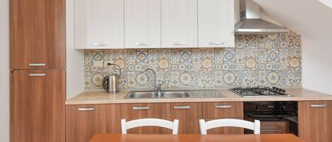 A kitchen with wooden cabinets, a tiled backsplash, a gas stove, and a sink.