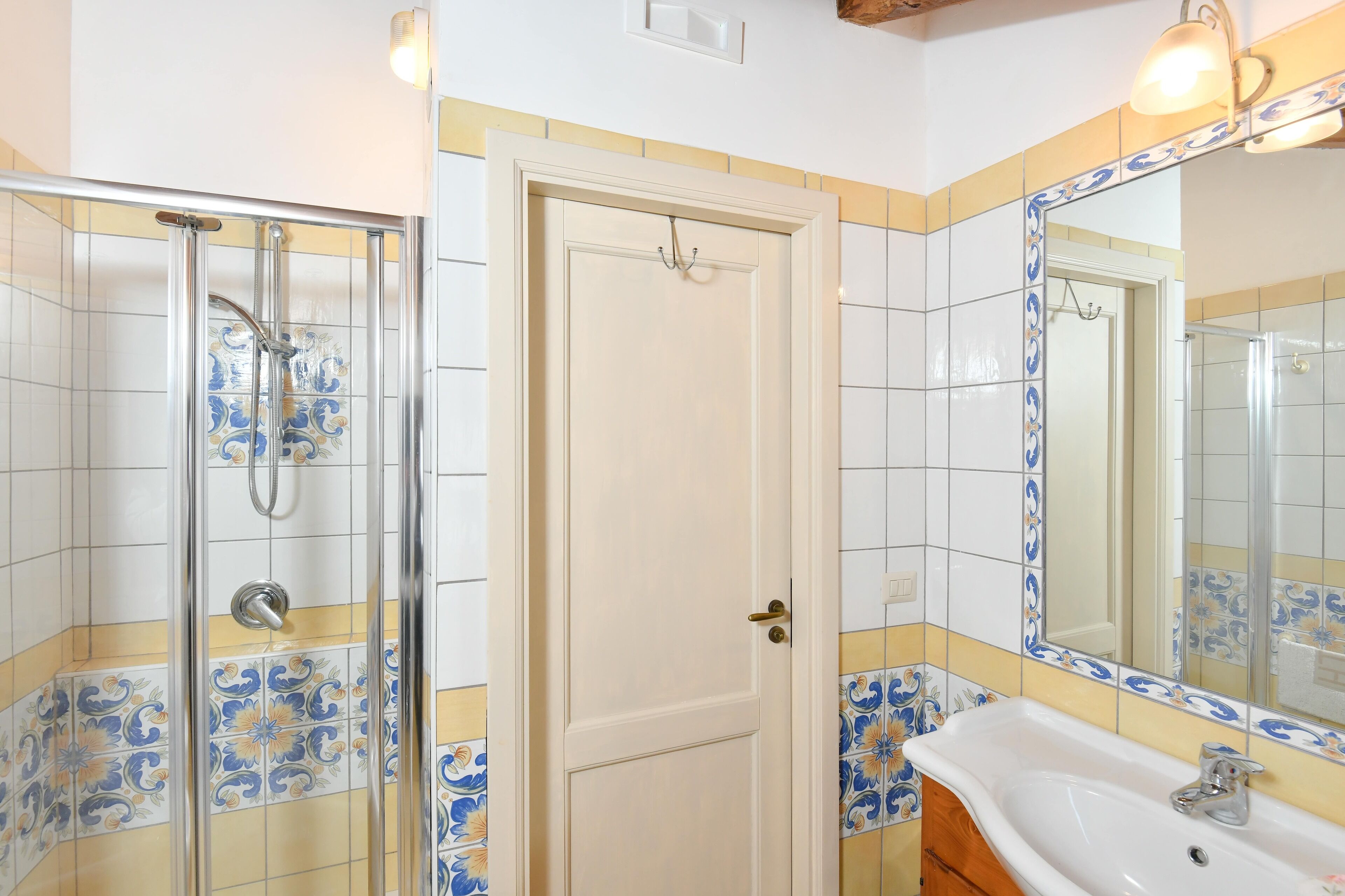 Une salle de bain avec une douche, un lavabo et un miroir.
