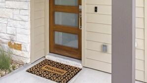 Une maison portant le numéro 101, une porte d’entrée ornée d’une guirlande et un paillasson.