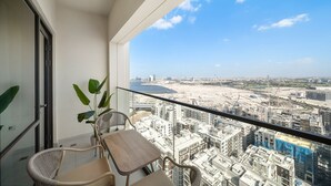 A balcony with a view of a cityscape and a body of water. - Stylish 1 BD Near the Lagoon in Creek Harbour (Dubai)