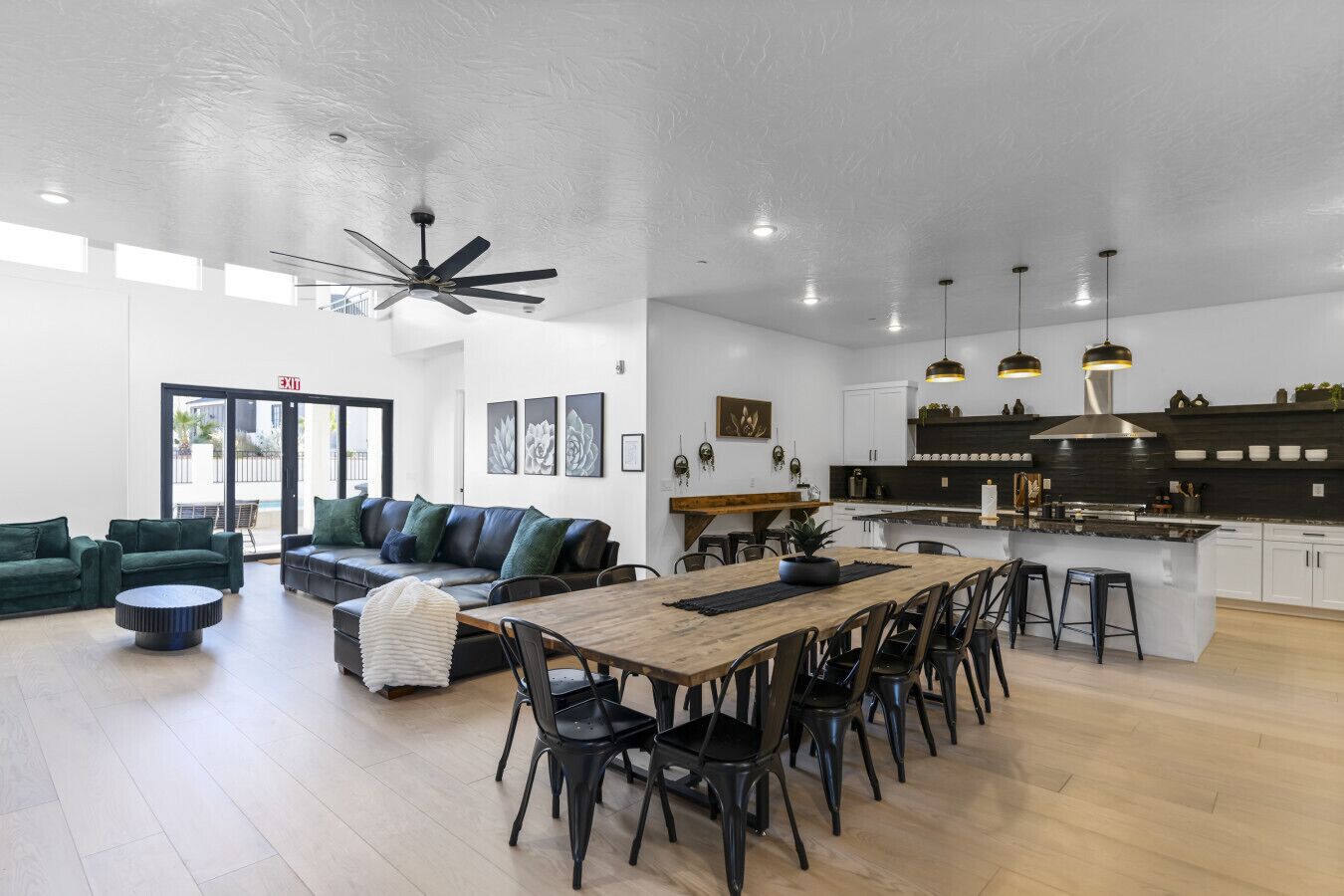 A spacious living area with a dining table, sofas, and a kitchen with modern appliances.