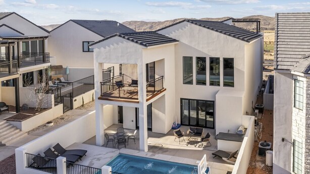 Ein modernes Mehrfamilienhaus mit Dachpool, Außenbereich und Blick auf die umliegende Landschaft.