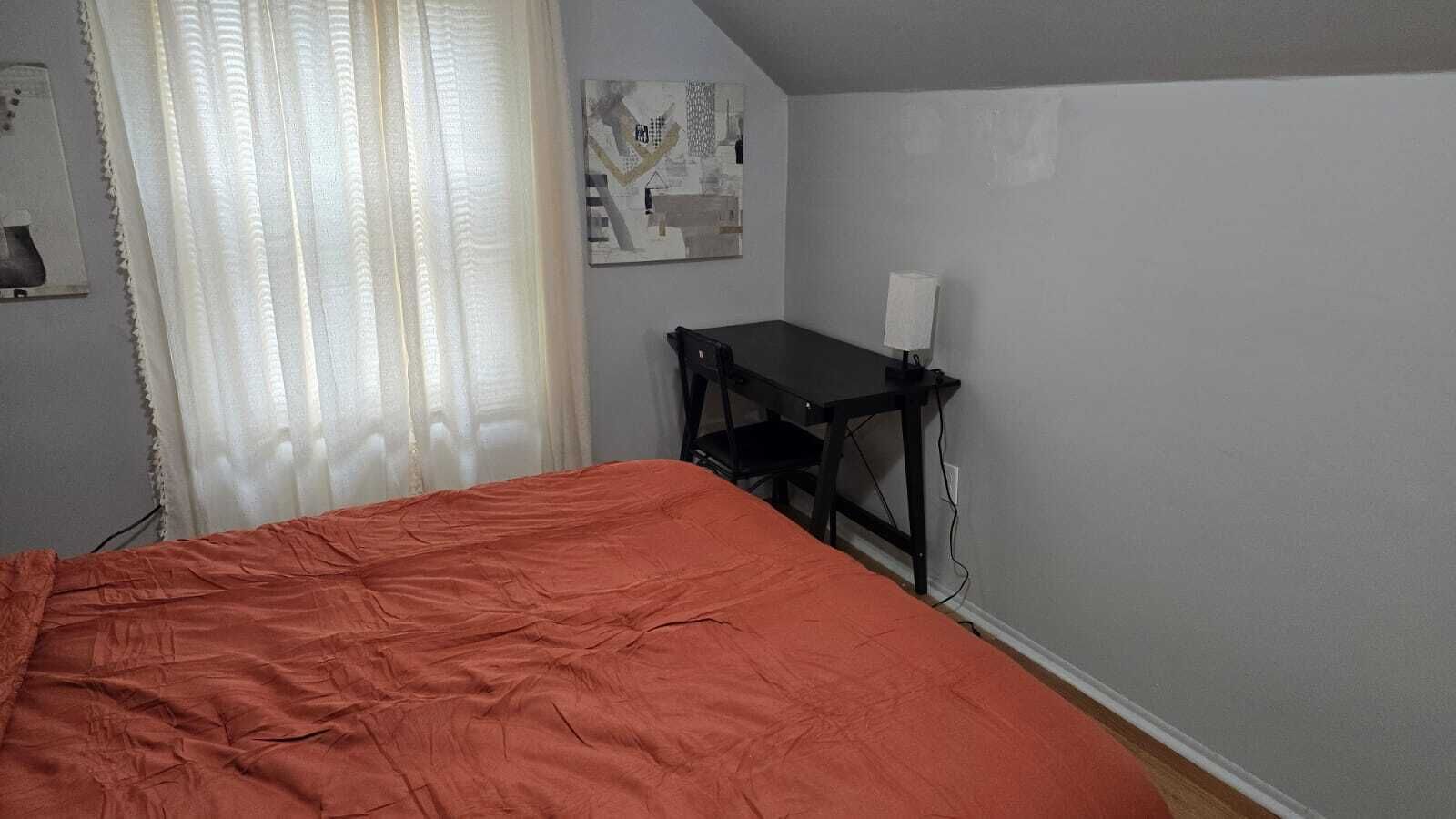 Ein Schlafzimmer mit einem Bett, einem Schreibtisch und einem Stuhl.